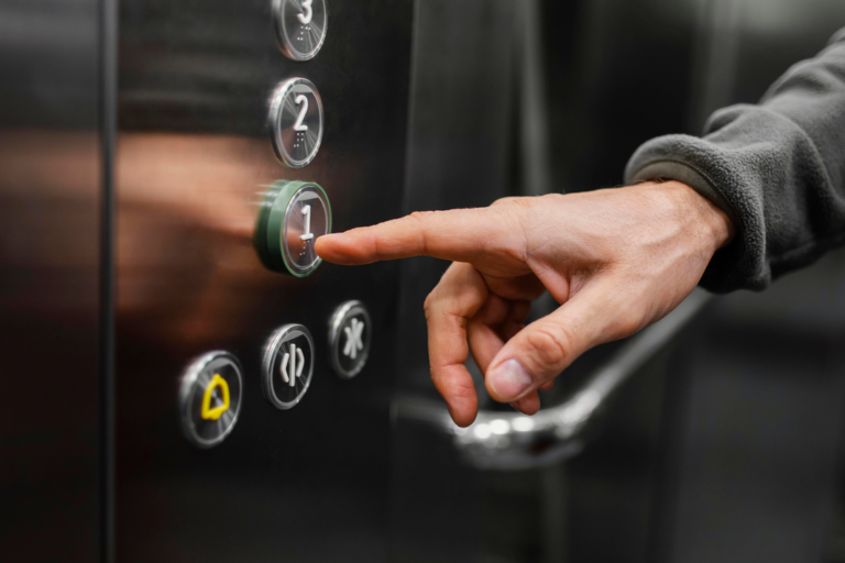 Man in elevator clicking the floor button